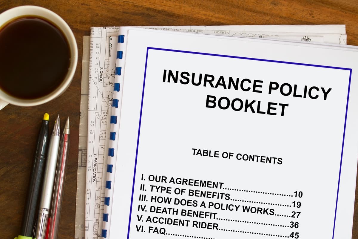 Insurance policy booklet with coffee and documents concept.