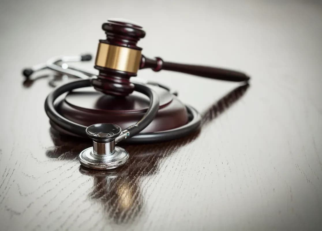 Gavel and Stethoscope on Reflective Table