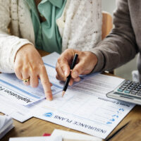Insurance health risk assessment with forms of paper on desk Insurance health risk assessment with forms of paper on desk