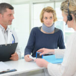 friendly female doctor with patient in office at reception