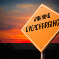 Overcharging on Warning Road Sign.