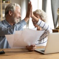 Happy elderly couple celebrate good news in letter