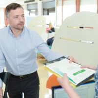 businessman at work wearing neck brace with crutches