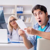 Male patient angry at expensive healthcare bill Male patient angry at expensive healthcare bill