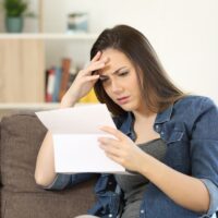 Concerned woman reading bad news in a letter