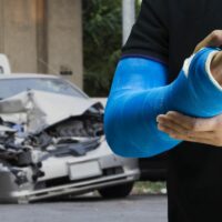 Man holding hand with blue bandage as arm injury with car accident concept.