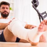 Portrait of a young man with injured leg at home Portrait of a young man with injured leg at home