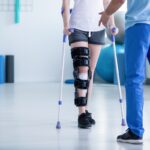 Professional physiotherapist supporting patient with orthopedic problem Professional physiotherapist supporting patient with orthopedic problem