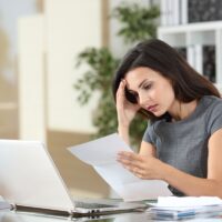 Worried office worker reading bad news in a letter Worried office worker reading bad news in a letter