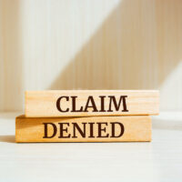 Wooden blocks with words 'Claim denied'.