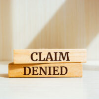 Wooden blocks with words 'Claim denied'. Wooden blocks with words 'Claim denied'.