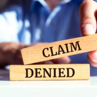 Wooden blocks with words 'Claim denied'.