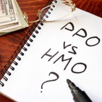 PPO vs HMO written in a note. Healthcare insurance concept.