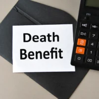 DEATH BENEFIT - words on white sheet on black envelope with calculator
