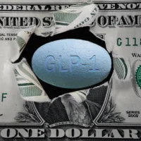 GLP-1 pill in a torn dollar bill